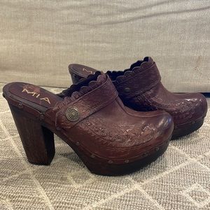 Brown leather high heeled clogs.